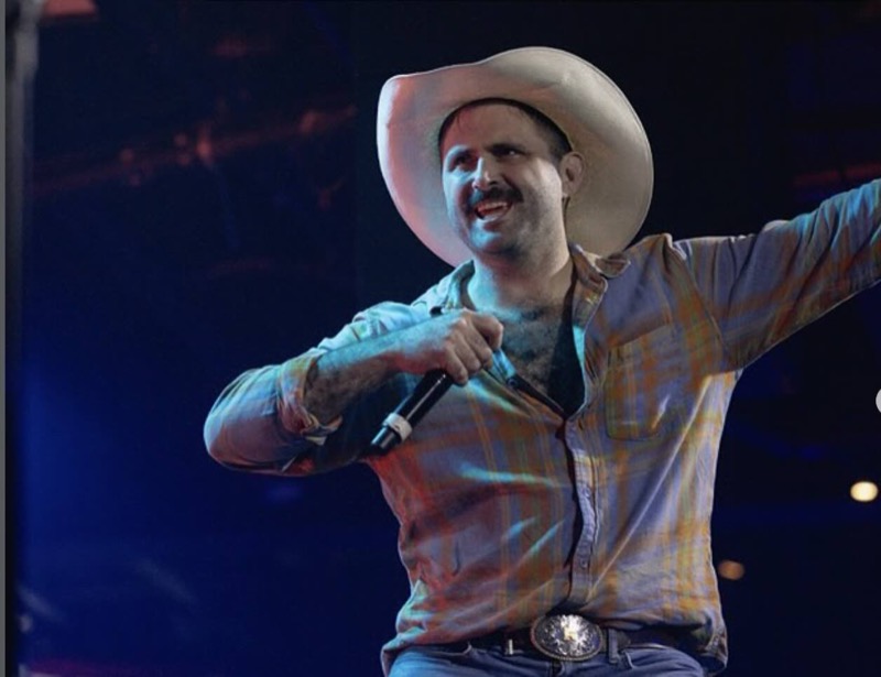 Scott Rowan in a cowboy hat, hosting with a microphone at Tipsy Rodeo